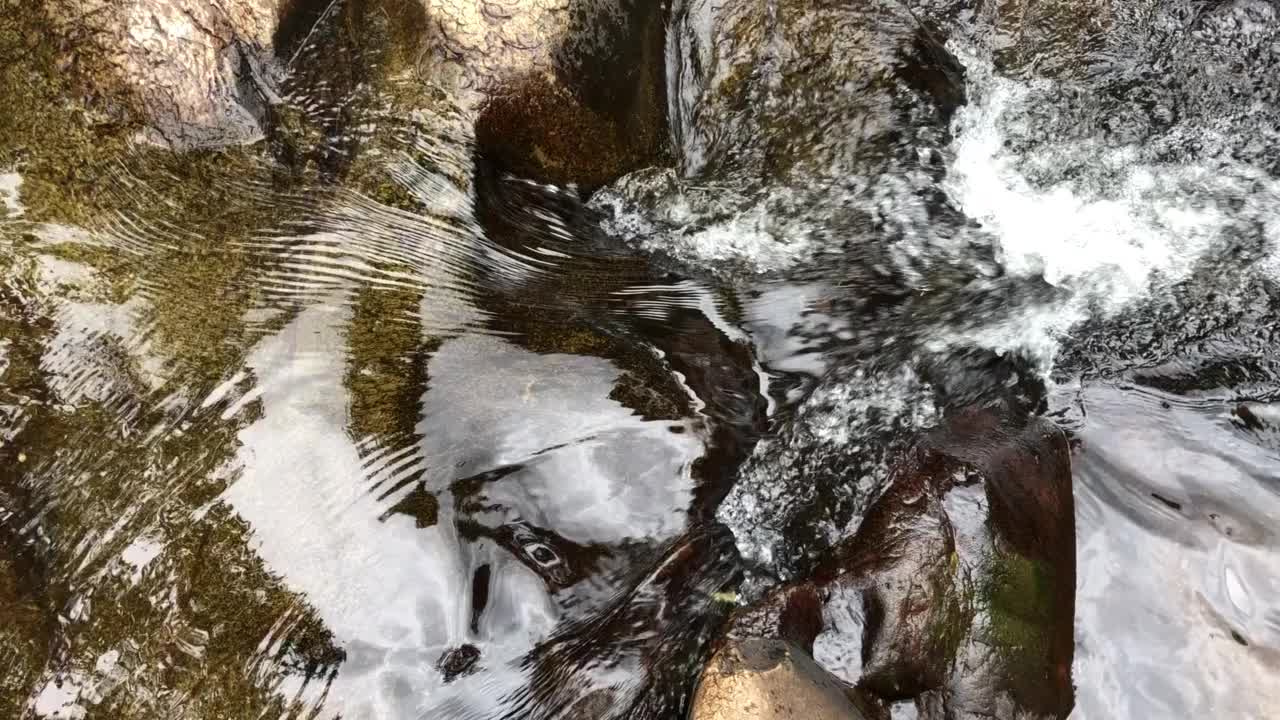 水从岩石上流过。山上的河水从岩石中流过。视频下载