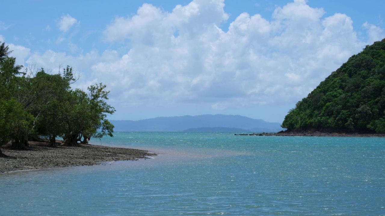 美丽的海浪和热带岛屿上的白色沙滩。在炎热的夏天，海边的沙滩上有柔软的海浪和明亮的云。放松和度假旅行的概念。视频素材