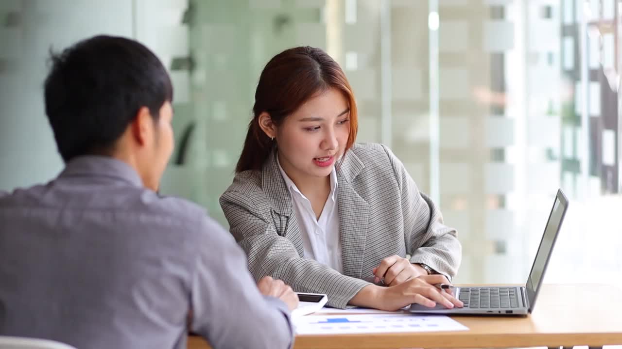 女商人与办公室同事讨论项目并分析商业计划。视频素材