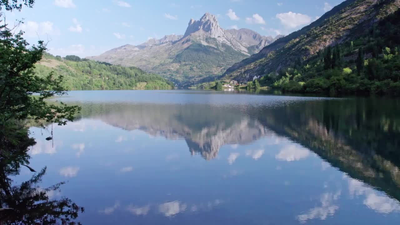 在湖面上快速飞行，湖面上倒映着一座高山。视频下载