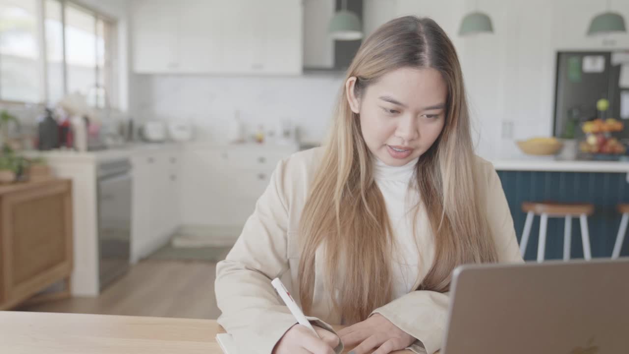 年轻的成年亚洲女性在家工作，远程学习，在线教学的概念视频素材