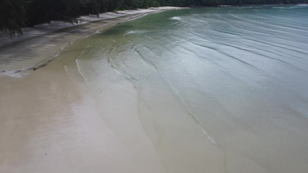 美丽的海浪和白色的沙滩在热带岛屿。从无人机俯瞰，在沙滩背景上的蓝色海洋的软波浪。度假休闲和旅行的概念。视频素材