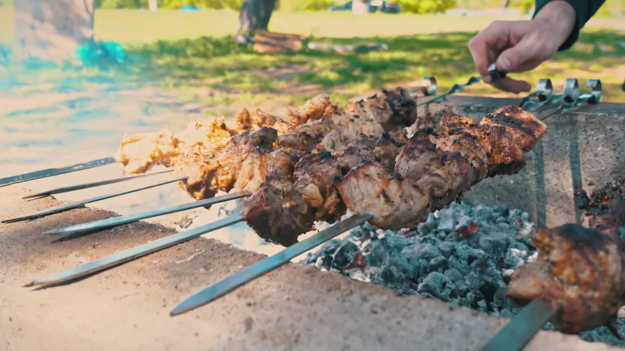 Juicy Shish Kebab on Skewers是油炸在火上和一个人翻转它视频素材