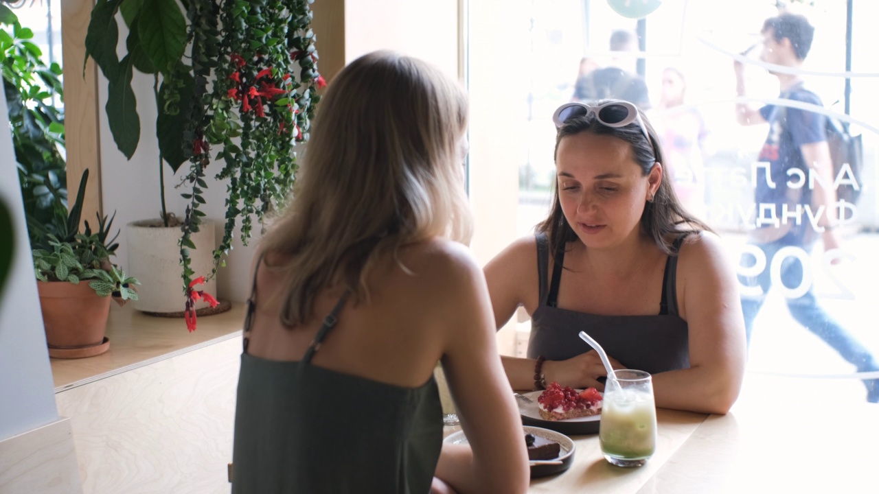 年轻漂亮的女人在咖啡店聊天视频素材