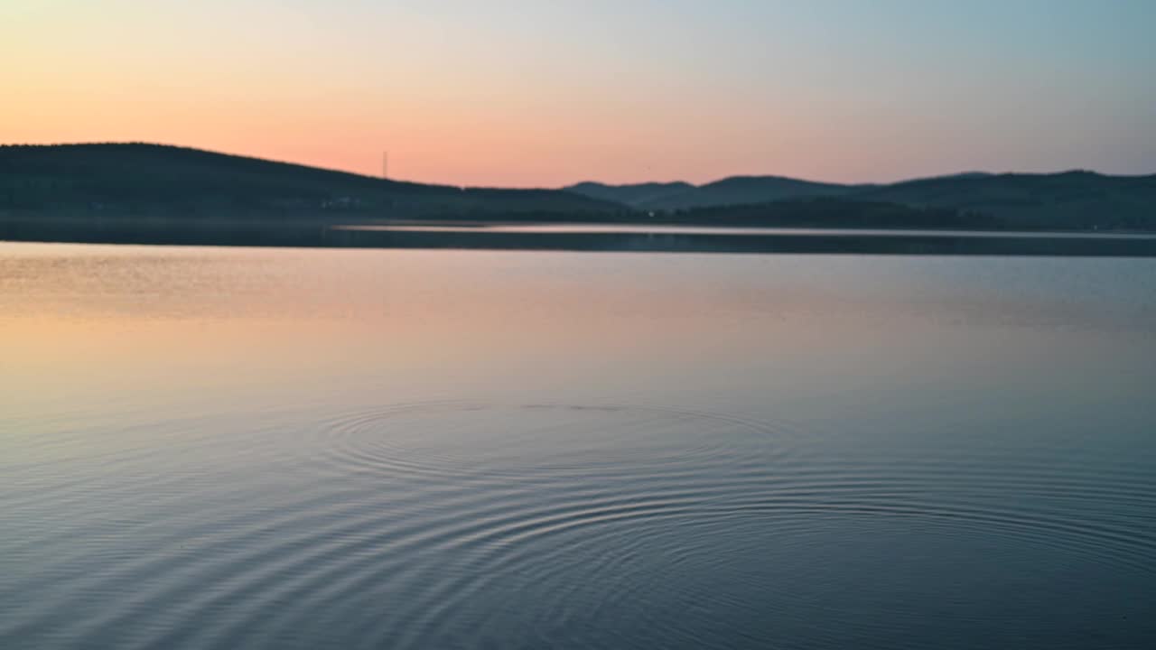 平静的湖面上的夏日夕阳视频素材