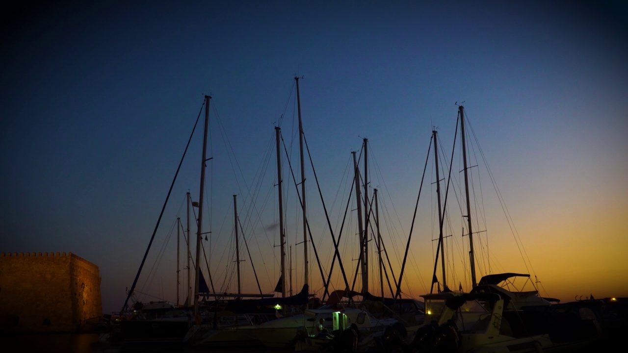 夕阳西下，游艇和摇摆桅杆的剪影映衬着夜空。美丽的背景拍摄在南部港口的度假小镇。视频素材