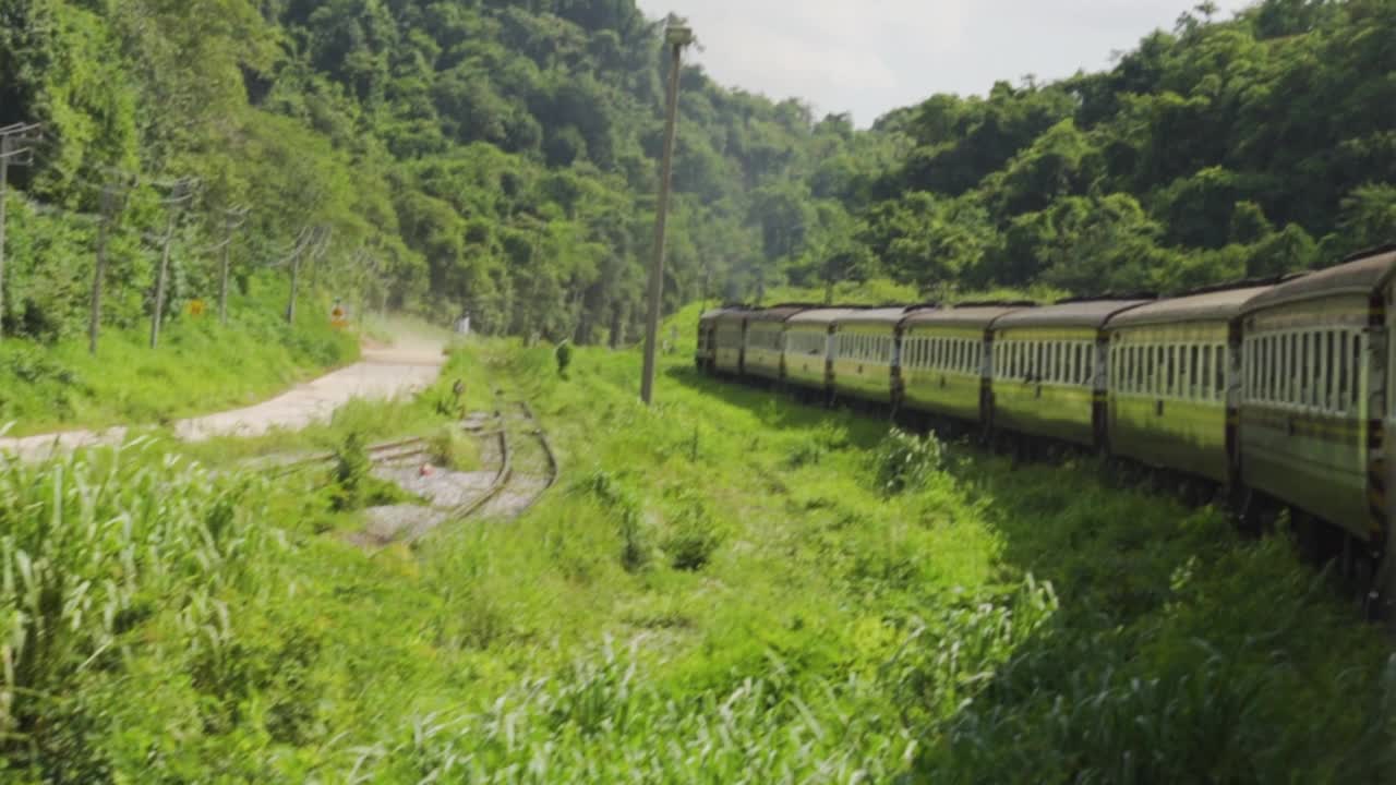 火车在轨道上运行的视图。泰国乡村及热带地区。东南亚氛围和感觉。大自然的新鲜。缓慢的运动。视频下载