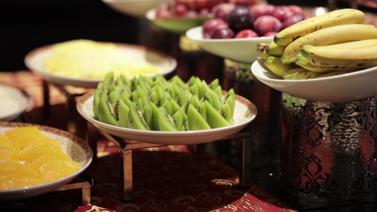 切片猕猴桃放在盘子里的水果在开放的自助餐，新鲜猕猴桃，即食猕猴桃视频素材