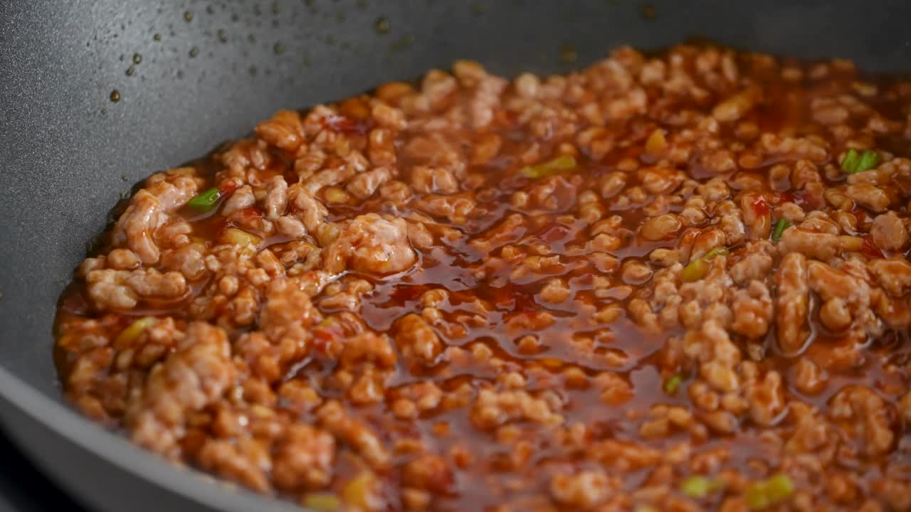 在家里做麻婆豆腐时，用辣酱炒猪肉。视频素材