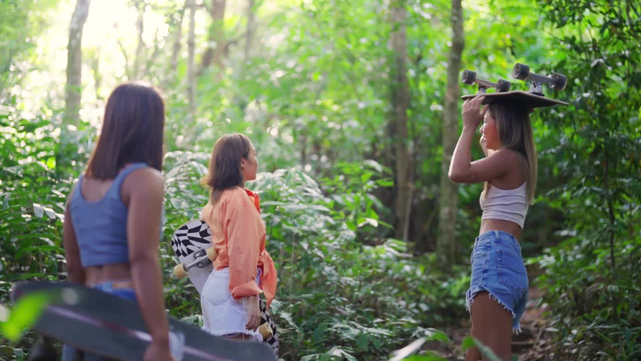 4K组健康的亚洲女性手持滑板徒步前往热带岛屿的山顶。视频素材