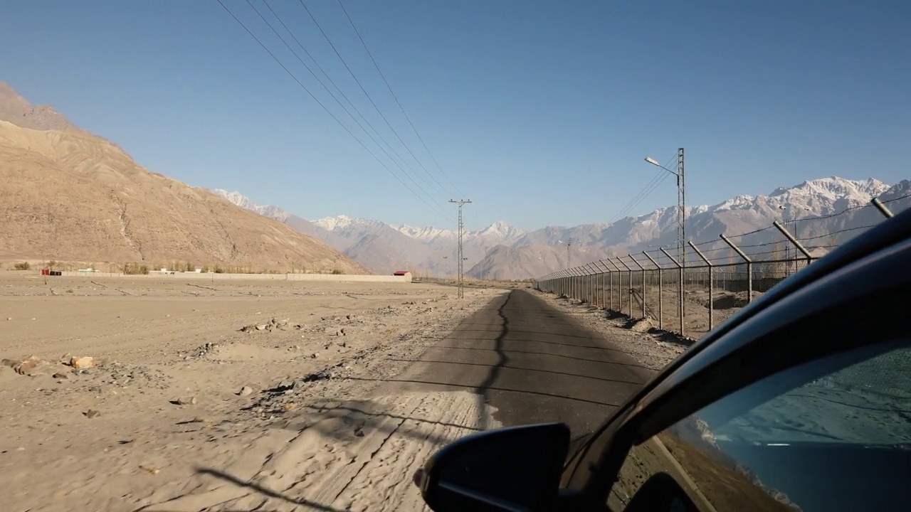 铁丝网围栏附近的道路在沙漠的山区视频素材