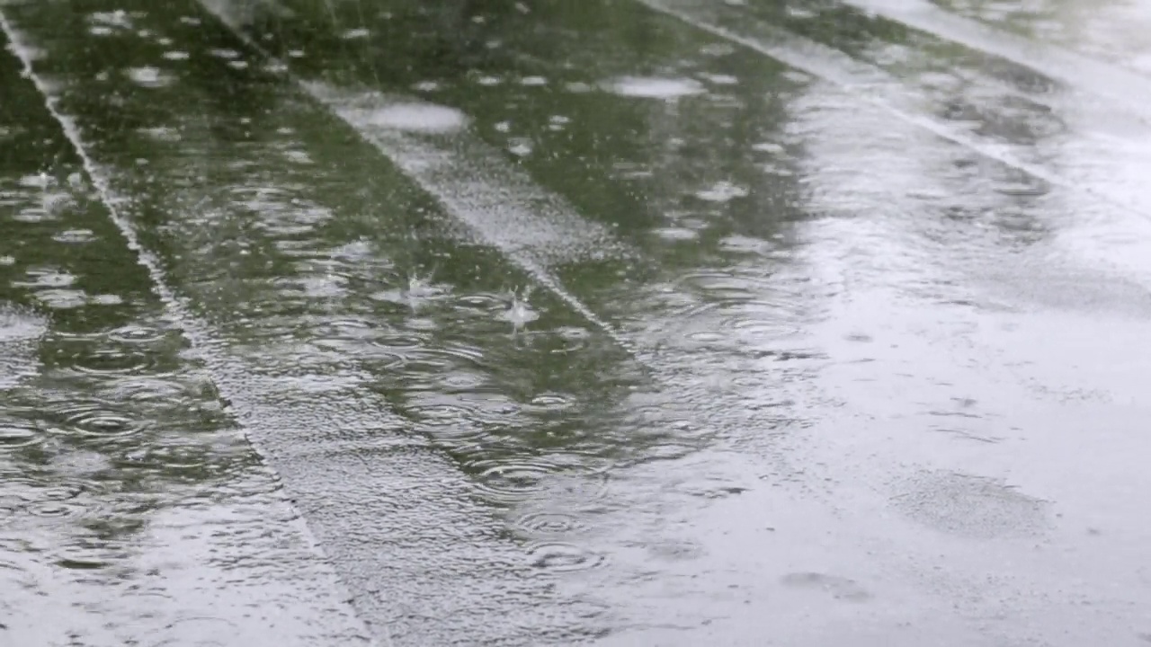 雨点敲打着屋顶，大雨滂沱。这座建筑的平屋顶覆盖着防水材料，可以防雨。橡胶、卷材屋面及防水材料。视频素材