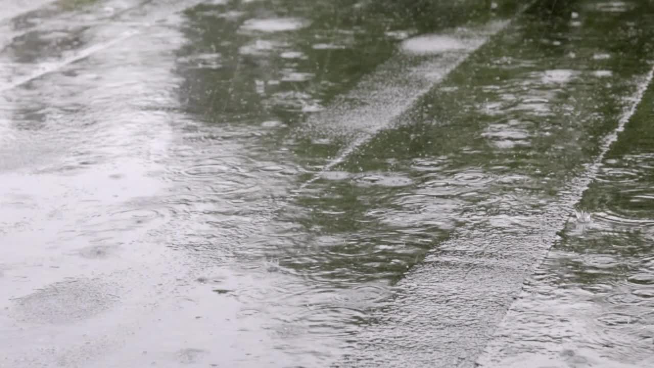 雨点敲打着屋顶，大雨滂沱。这座建筑的平屋顶覆盖着防水材料，可以防雨。橡胶、卷材屋面及防水材料。视频素材