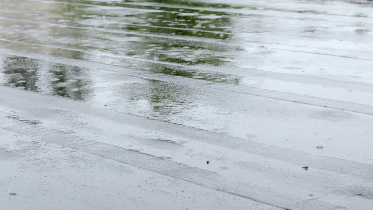 雨点敲打着屋顶，大雨滂沱。这座建筑的平屋顶覆盖着防水材料，可以防雨。橡胶、卷材屋面及防水材料。视频素材