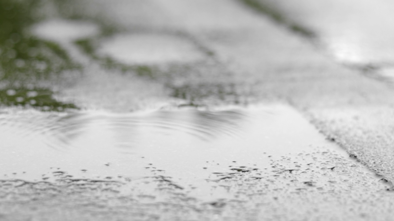 雨点敲打着屋顶，大雨滂沱。这座建筑的平屋顶覆盖着防水材料，可以防雨。橡胶、卷材屋面及防水材料。视频素材