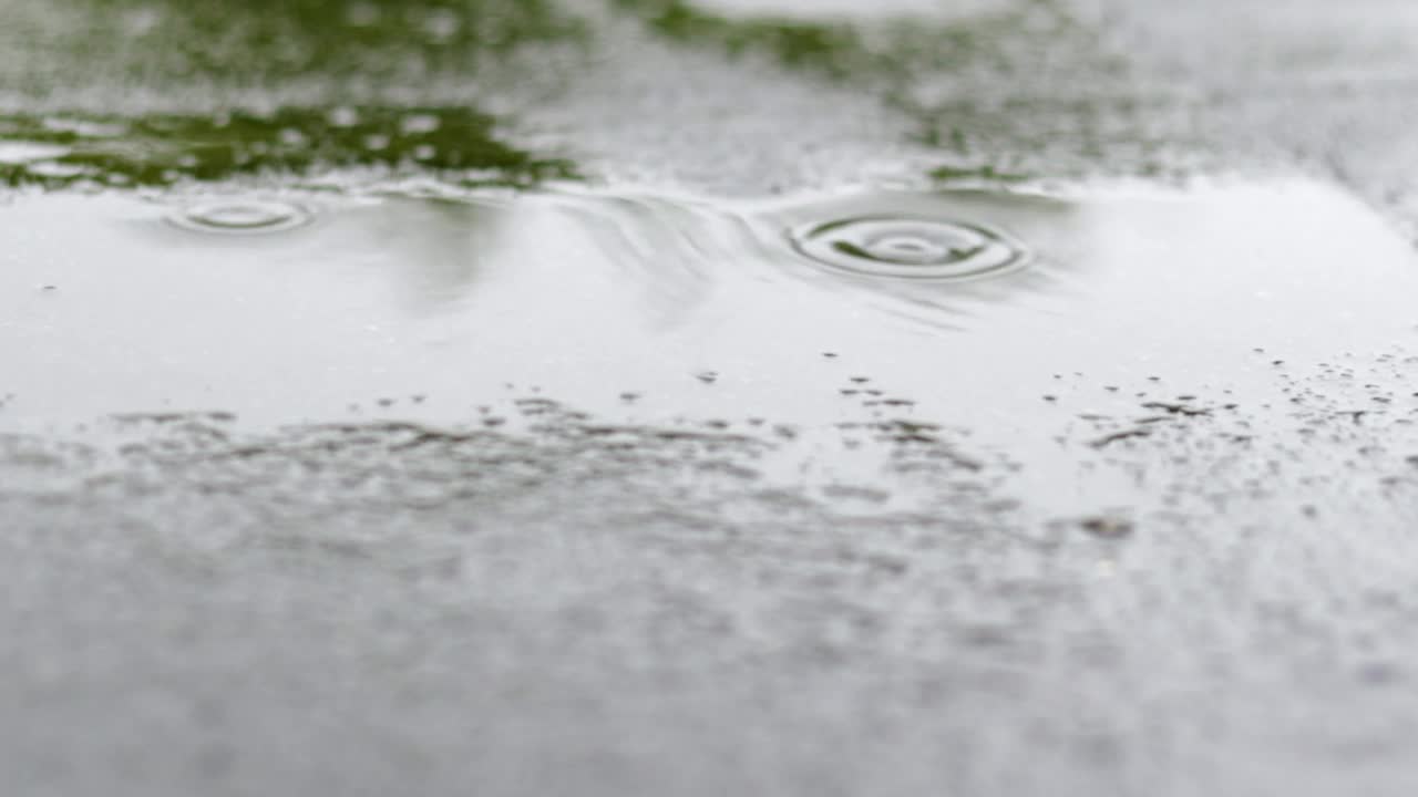 雨点敲打着屋顶，大雨滂沱。这座建筑的平屋顶覆盖着防水材料，可以防雨。橡胶、卷材屋面及防水材料。视频素材