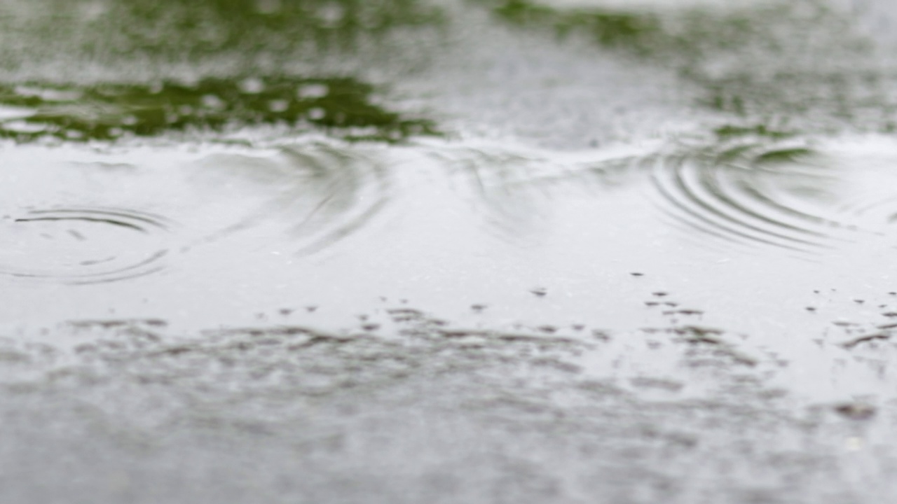 雨点敲打着屋顶，大雨滂沱。这座建筑的平屋顶覆盖着防水材料，可以防雨。橡胶、卷材屋面及防水材料。视频素材