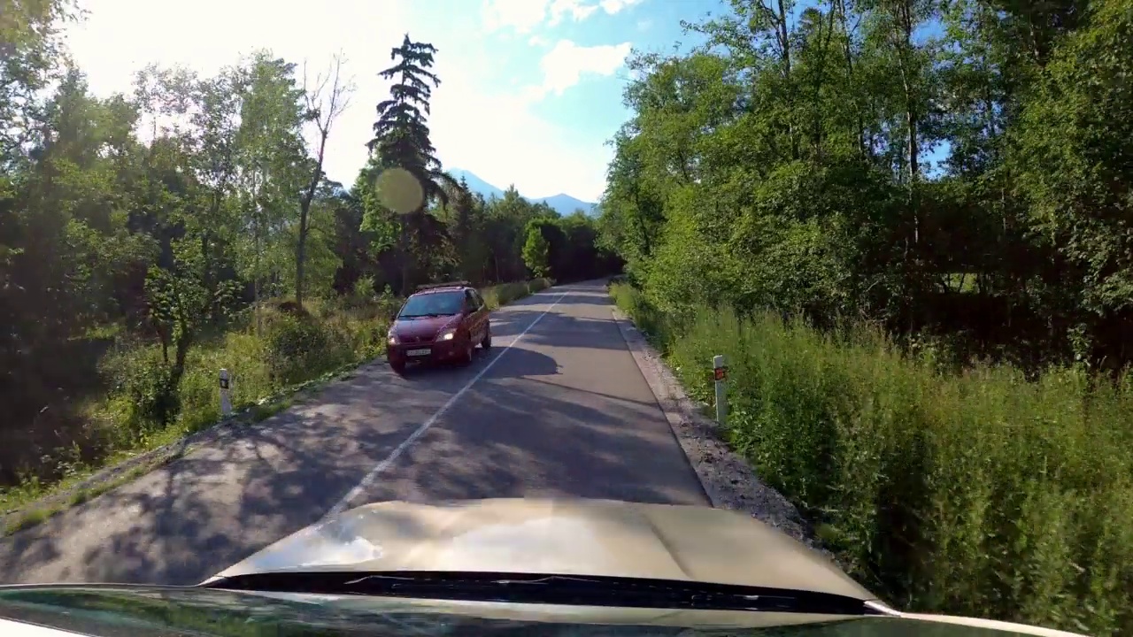 POV拍摄的一辆汽车沿着森林和山脉的道路行驶。夏天开车旅行视频素材