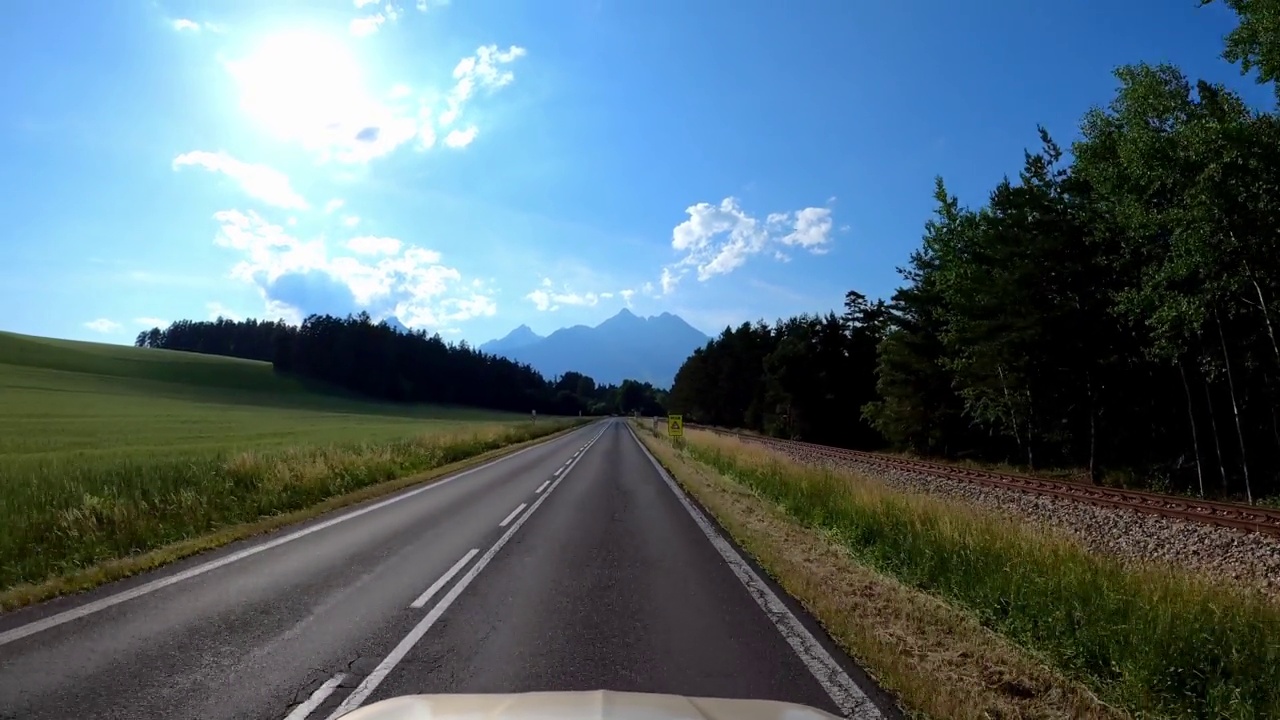 POV拍摄的一辆汽车沿着森林和山脉的道路行驶。夏天开车旅行视频素材