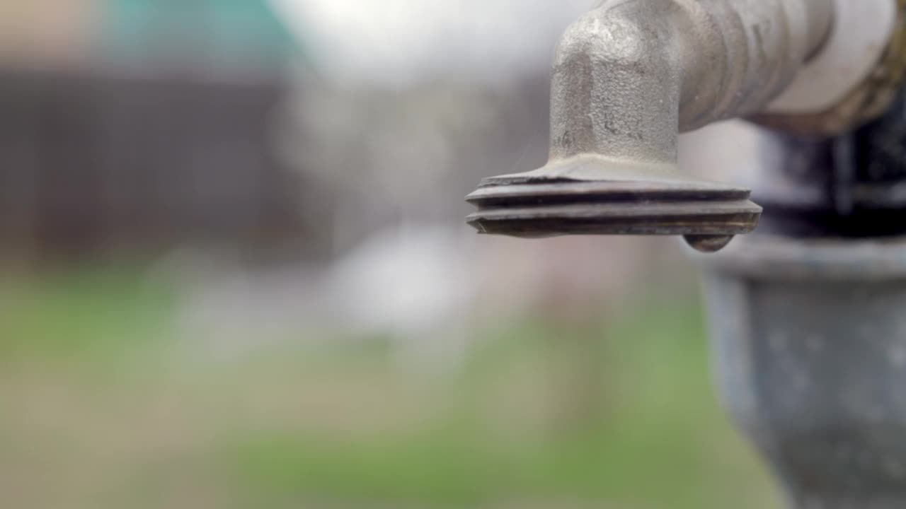 水龙头以自然为背景。打开或关闭水龙头节约用水表明缺水问题。有日光的乡村喷泉。背景模糊选择性对焦。视频素材