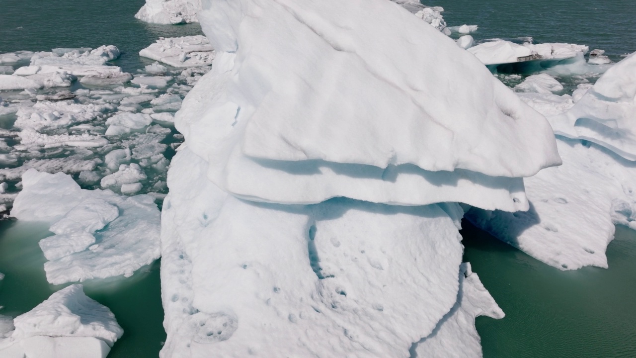 在Jokulsarlon冰川泻湖的一座巨大冰山上空飞行。不可思议的风景视频素材