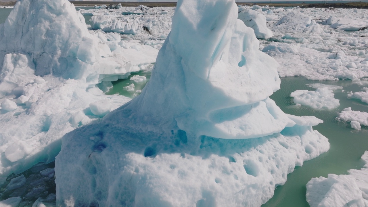 在Jokulsarlon冰川泻湖的一座巨大冰山上空飞行。不可思议的风景视频素材