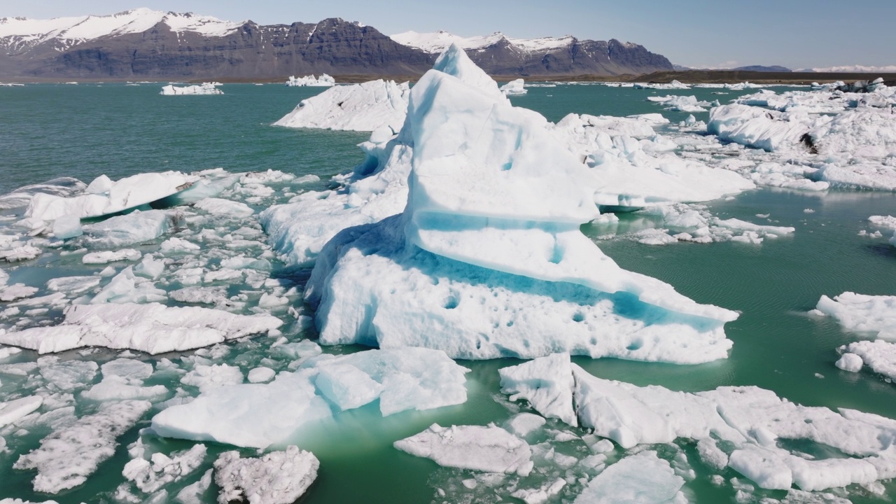 在Jokulsarlon冰川泻湖的一座巨大冰山上空飞行。不可思议的风景视频素材