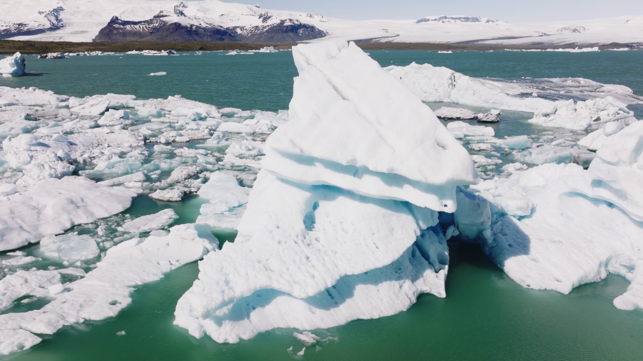 在Jokulsarlon冰川泻湖的一座巨大冰山上空飞行。不可思议的风景视频素材