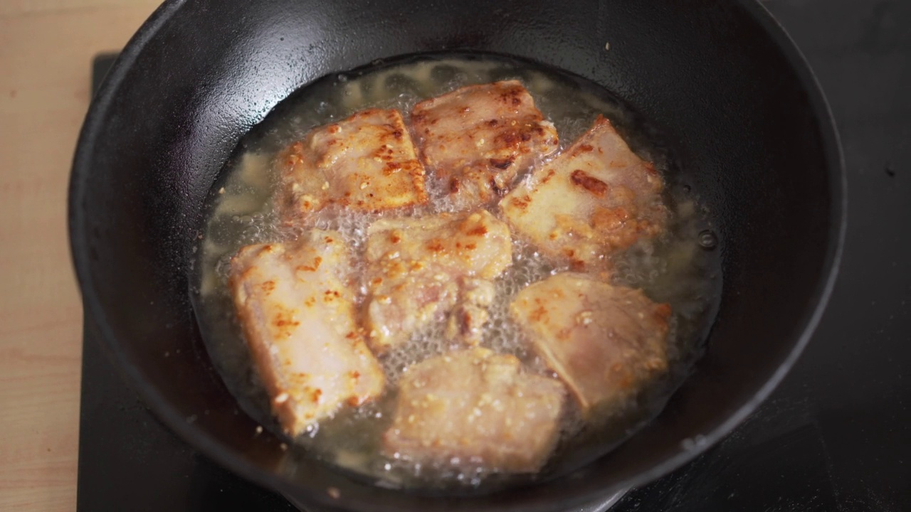 厨房里煎锅里的油炸五花肉。不健康的亚洲食物胆固醇高，晚餐准备肉类视频素材