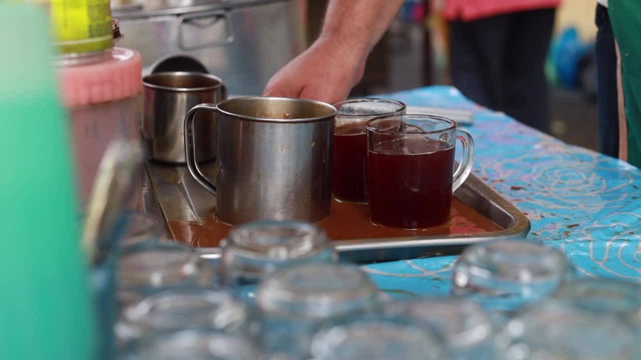 马来西亚槟城的一个路边摊上，小贩正在用炼乳制作奶茶，又称“茶塔”。视频素材