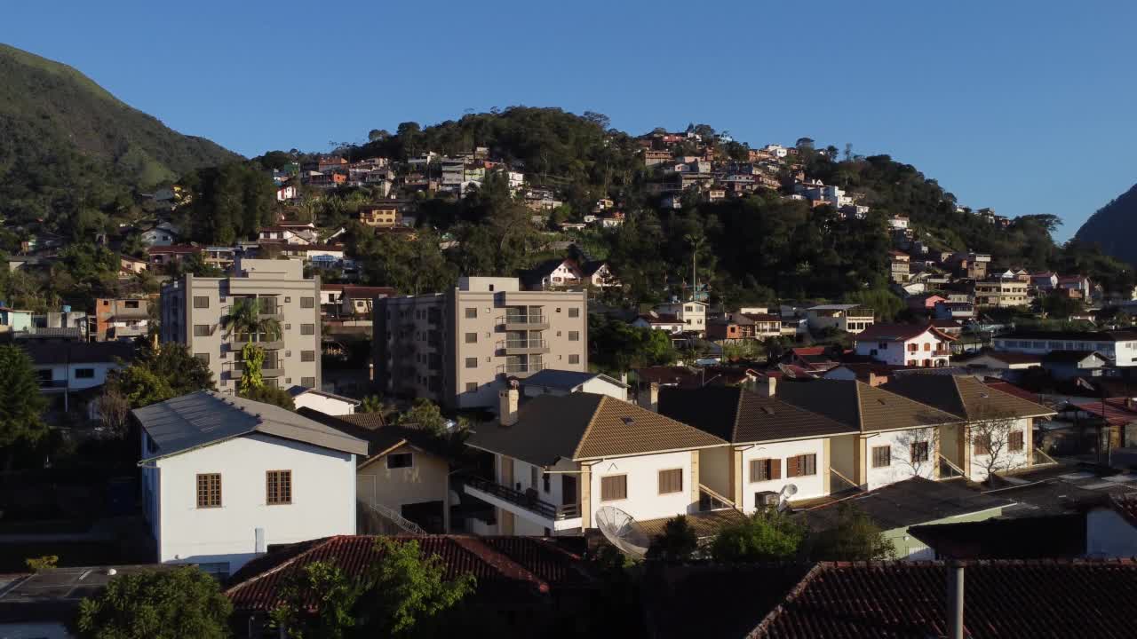 城市的鸟瞰图Teresópolis。在巴西里约热内卢的山区，有蓝色的天空和许多房子。无人驾驶飞机。苏茜,Teresopolis。阳光明媚的一天。日出视频素材