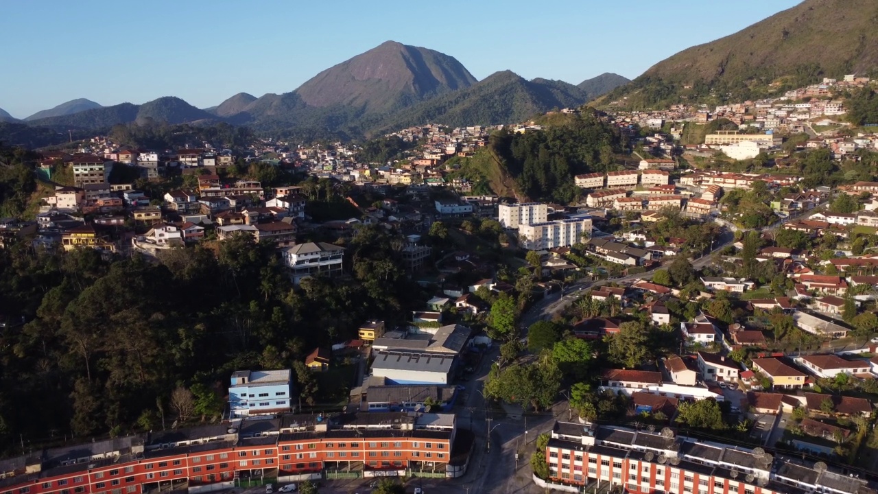 城市的鸟瞰图Teresópolis。在巴西里约热内卢的山区，有蓝色的天空和许多房子。无人驾驶飞机。苏茜,Teresopolis。阳光明媚的一天。日出视频素材