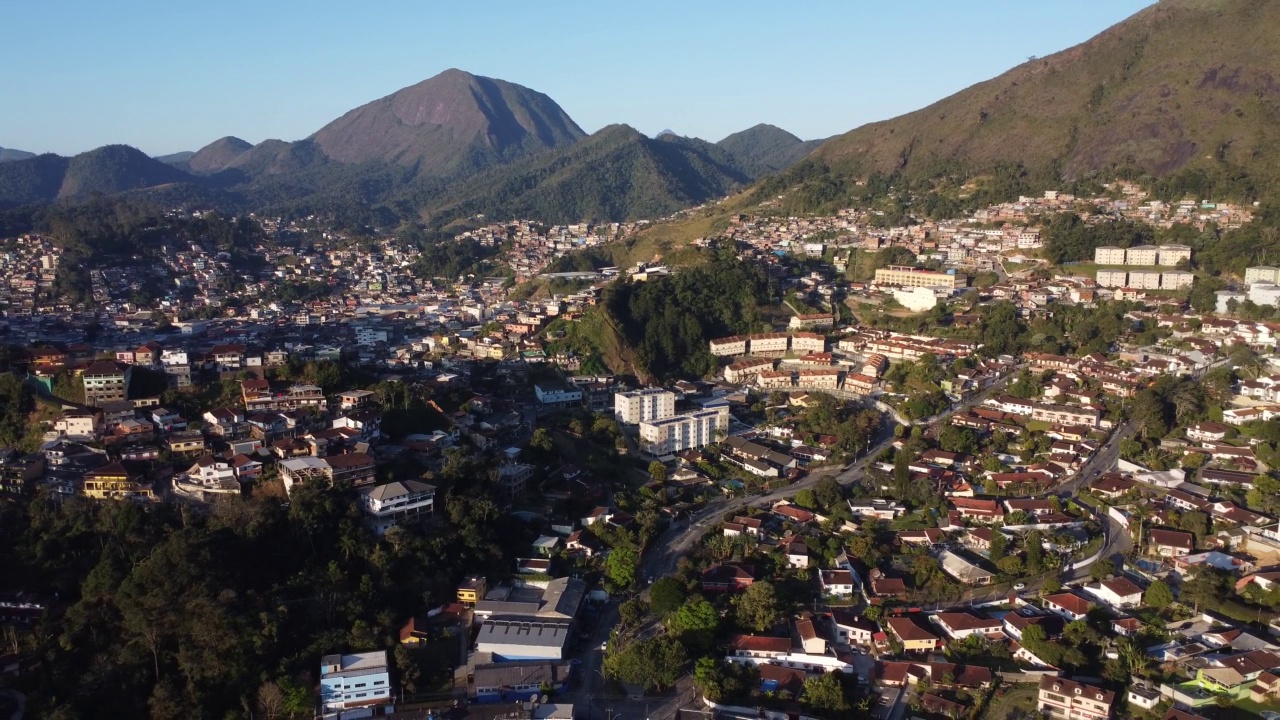 城市的鸟瞰图Teresópolis。在巴西里约热内卢的山区，有蓝色的天空和许多房子。无人驾驶飞机。苏茜,Teresopolis。阳光明媚的一天。日出视频素材