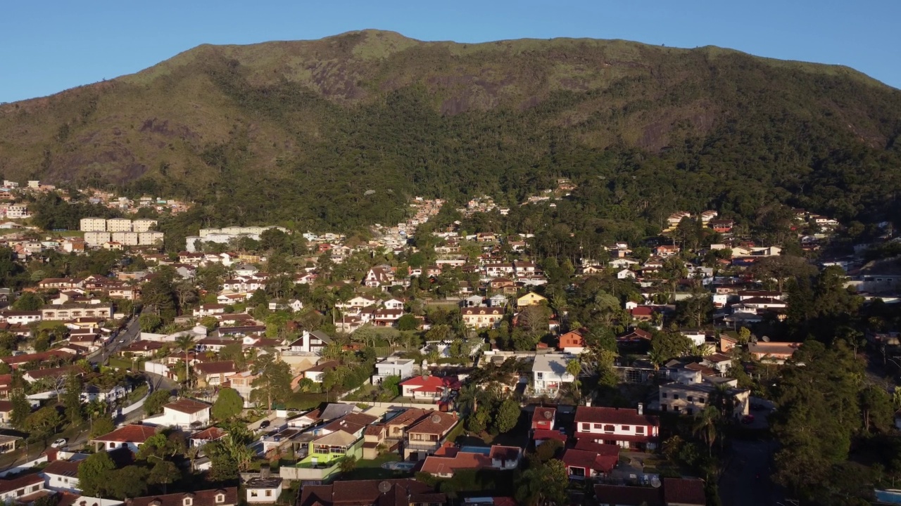 城市的鸟瞰图Teresópolis。在巴西里约热内卢的山区，有蓝色的天空和许多房子。无人驾驶飞机。苏茜,Teresopolis。阳光明媚的一天。日出视频素材