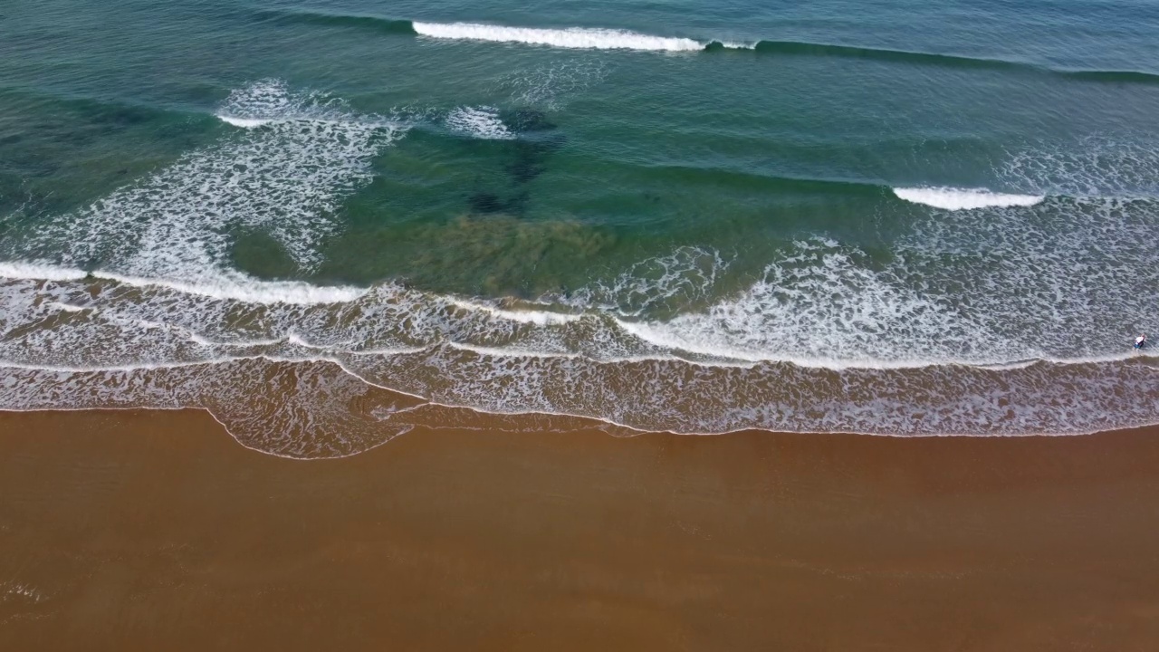 4k的无人机带着海浪飞过海滩岸边的静态视频视频素材