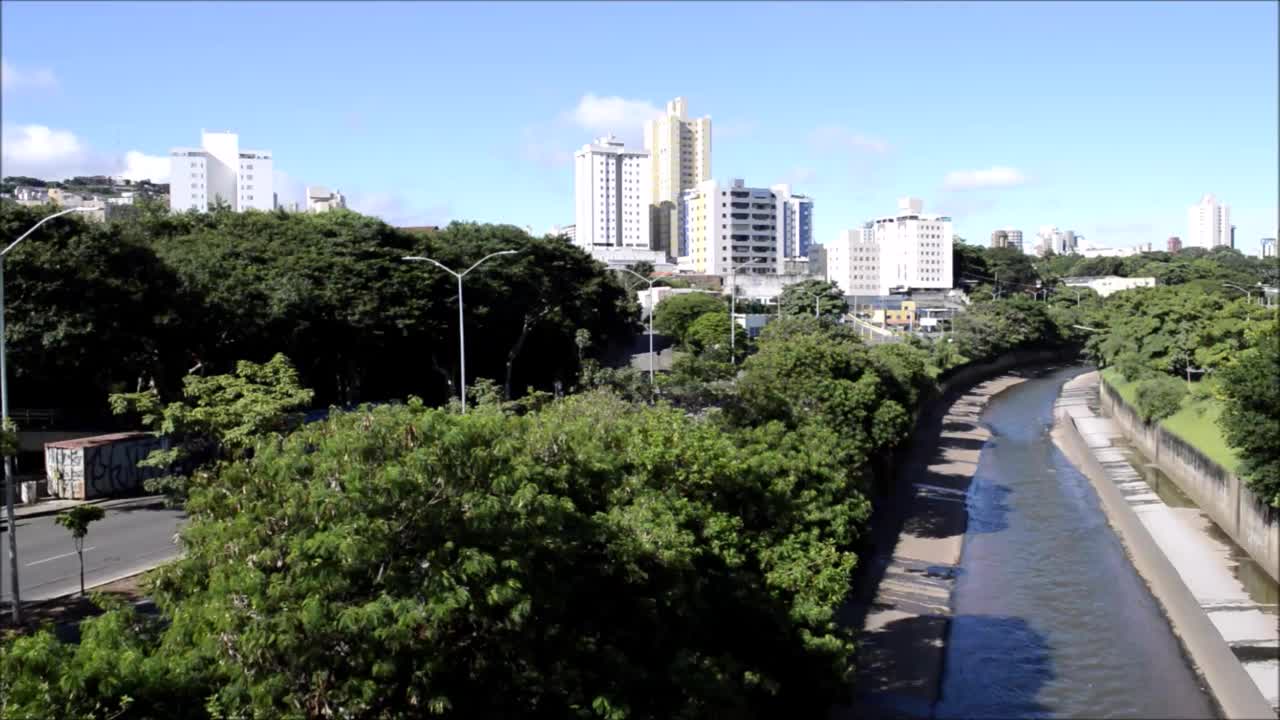 阿鲁达河，树木，风，交通，贝洛奥里藏特市的建筑。巴西。蓝天少云。视频下载