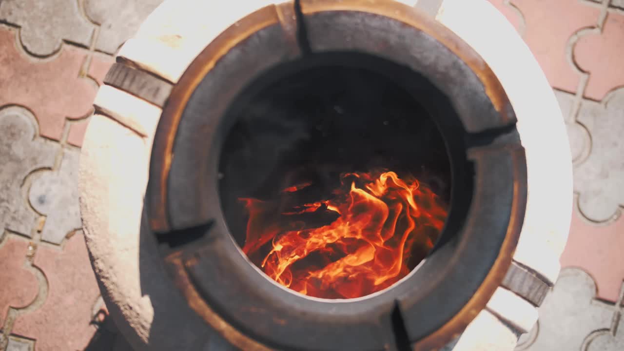 筒状泥炉。在tandoor里面燃烧木头。在准备烤串之前，先把烤炉预热一下。在烤炉里煮肉。视频素材