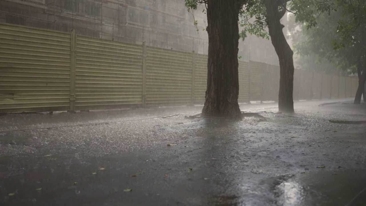 城里下起了暴雨。雨滴落在柏油路上视频素材