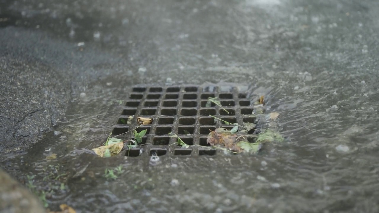 雨水流入雨水沟的特写。城里下起了暴雨。视频素材