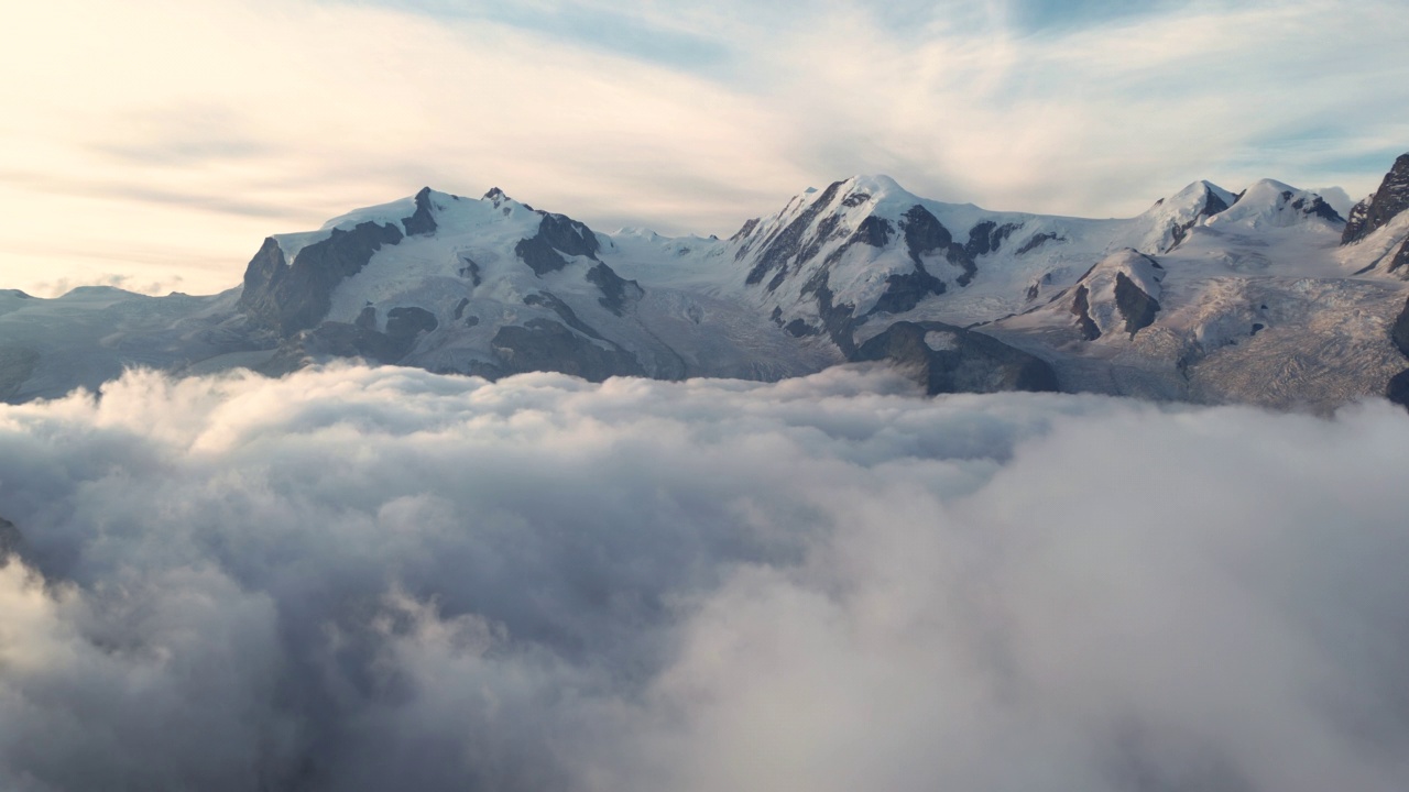 空中拍摄的瑞士阿尔卑斯山高雪山在瑞士移动拍摄在日出时间的云层之上视频素材