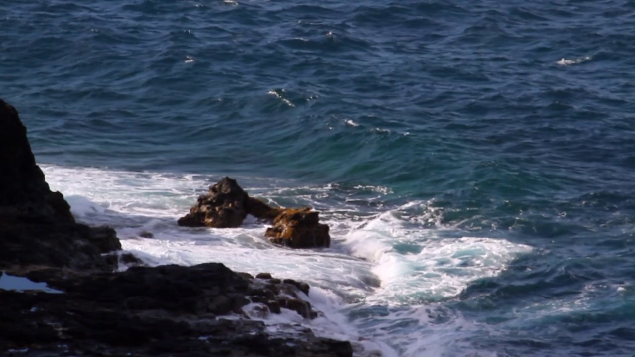 海水在潮湿的岩石上溅起水花——夏威夷考艾岛视频素材