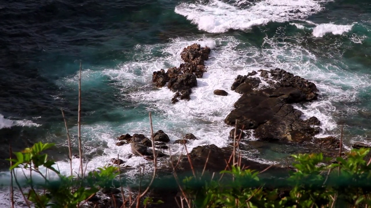 阳光明媚的日子里，海浪拍打在岩石上的美丽景色-夏威夷考艾岛视频素材