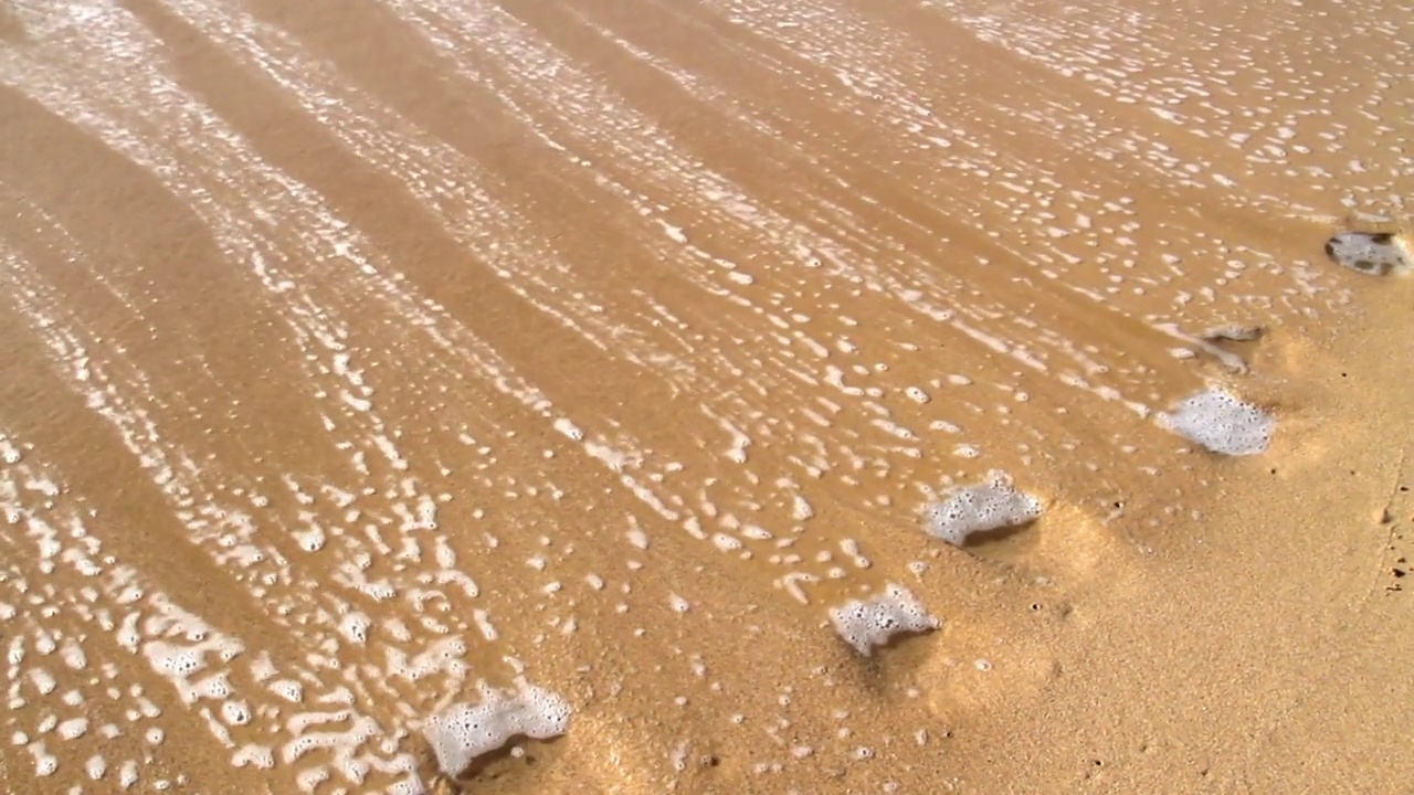 阳光明媚的日子里，海浪在海滩上溅起水花——夏威夷考艾岛视频素材