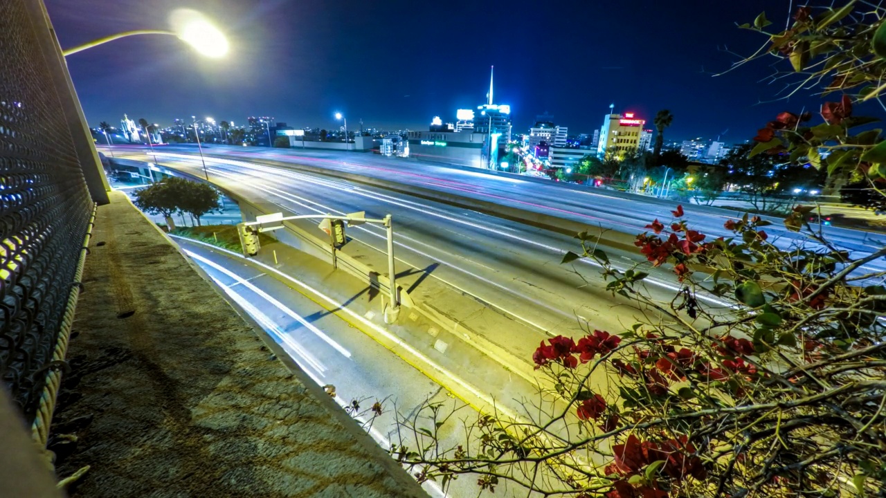 封锁延时拍摄的车辆移动在桥梁道路在城市对晴朗的天空-洛杉矶，加州视频素材