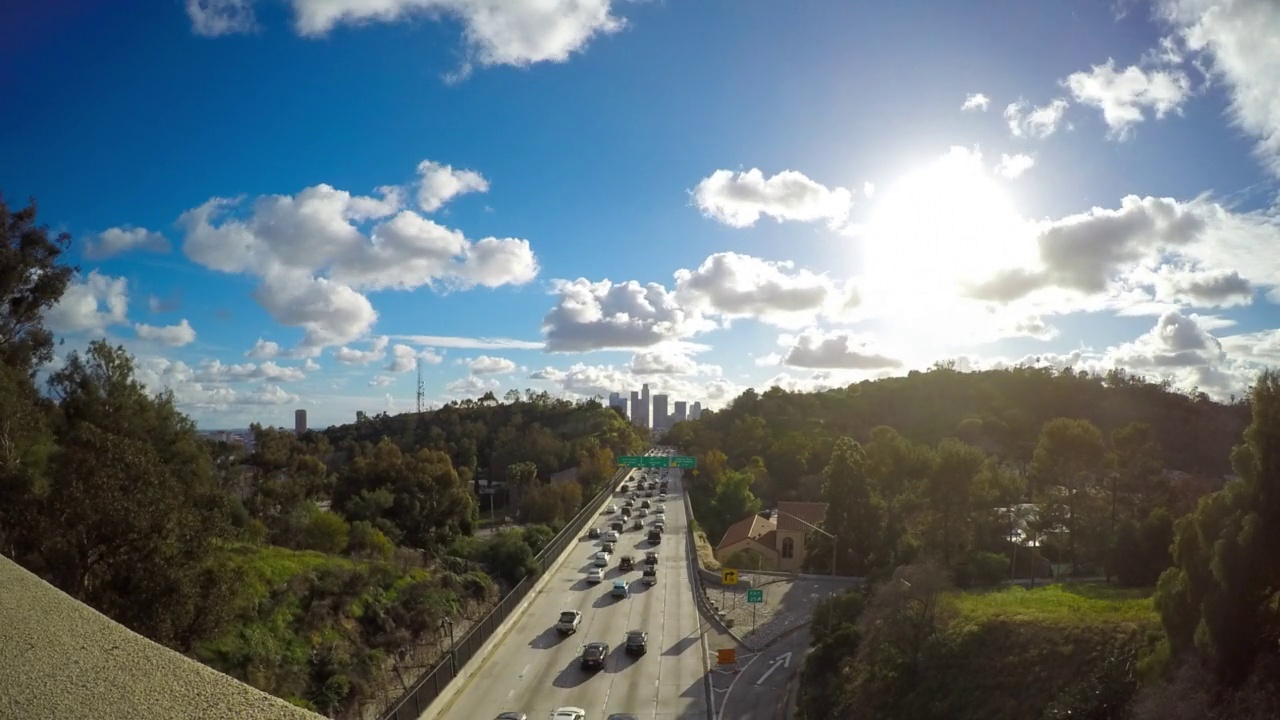 在多云的天空下行驶在城市道路上的汽车的空中延时拍摄-洛杉矶，加利福尼亚视频素材