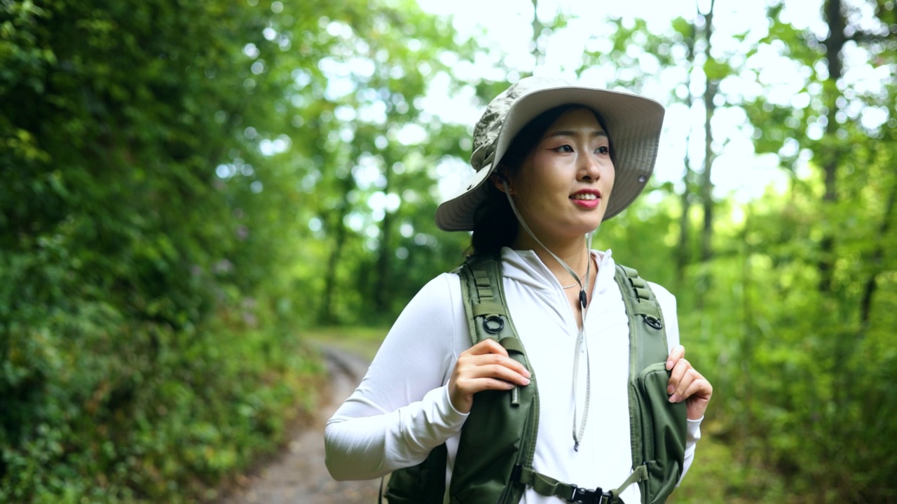 年轻女子徒步在森林道路视频素材