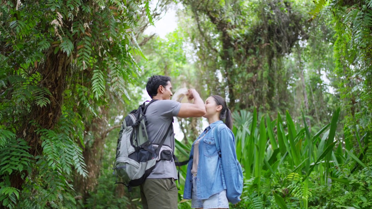 4K年轻的亚洲夫妇一起在热带森林徒步旅行。视频素材