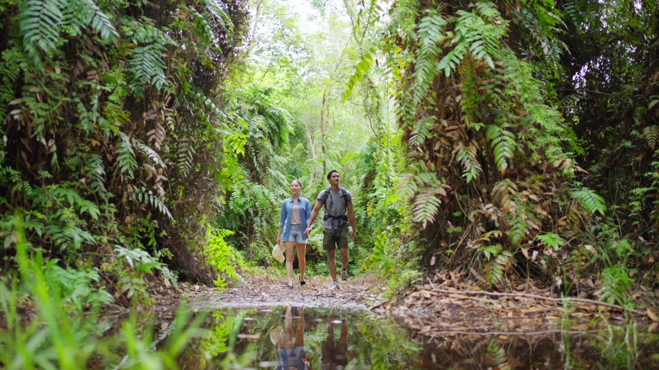 4K年轻的亚洲夫妇一起在热带森林徒步旅行。视频素材