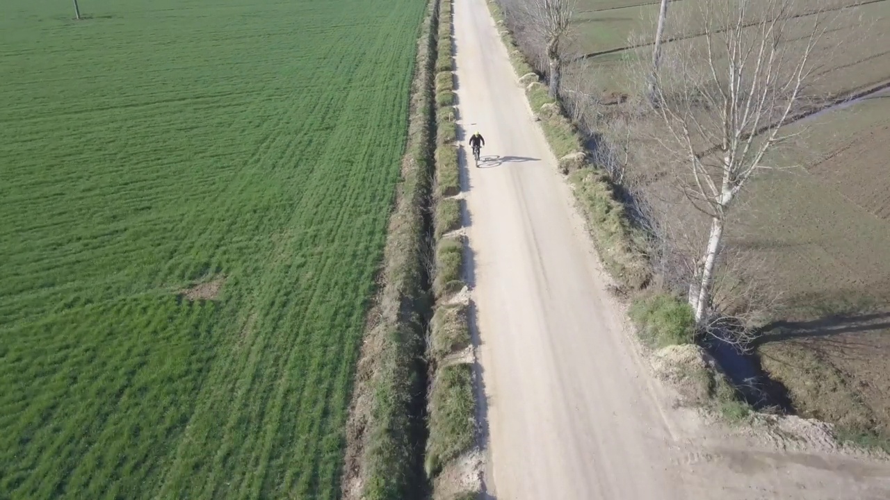 无人机跟踪在农村骑自行车。英雄交响曲路视频素材