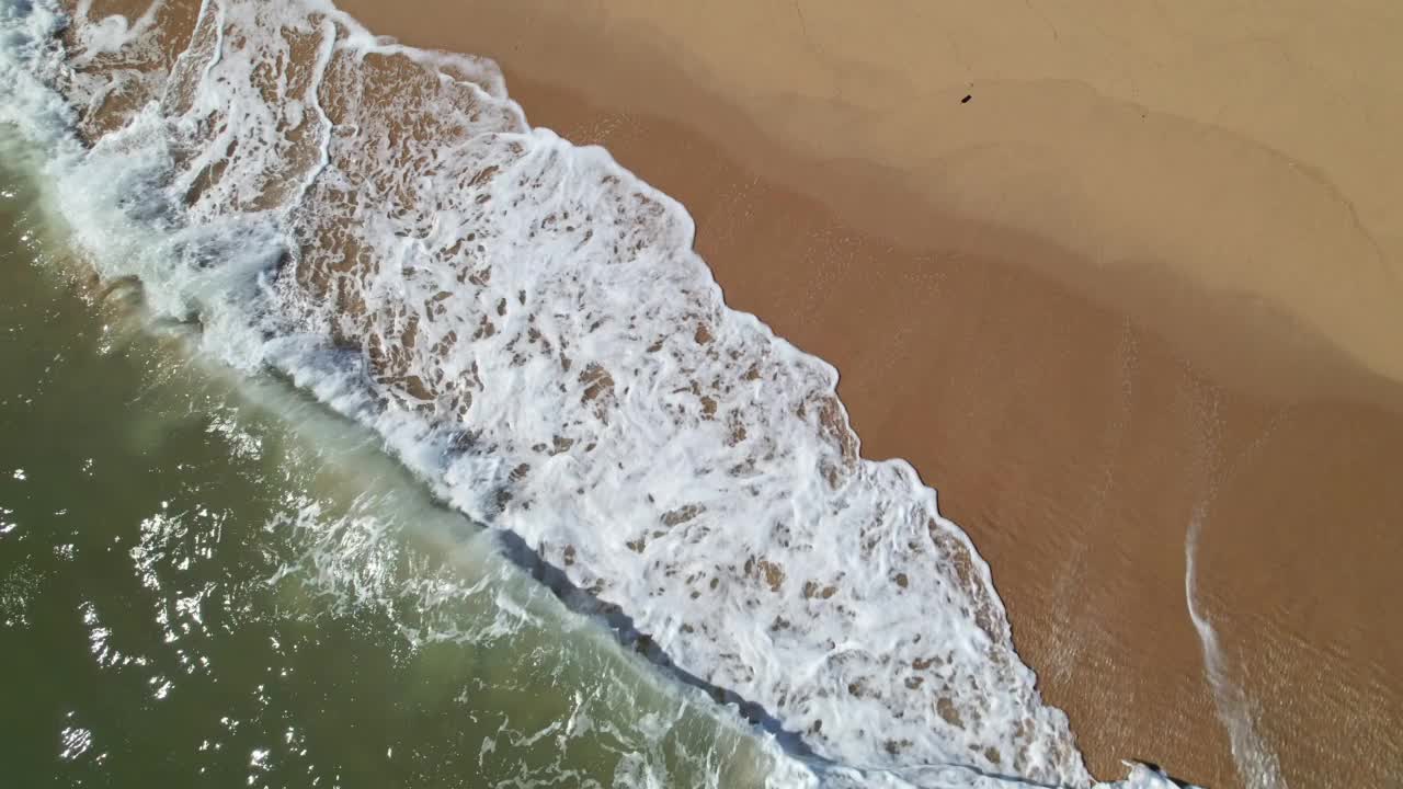 盘旋着，俯瞰着海浪拍打着沙滩视频素材